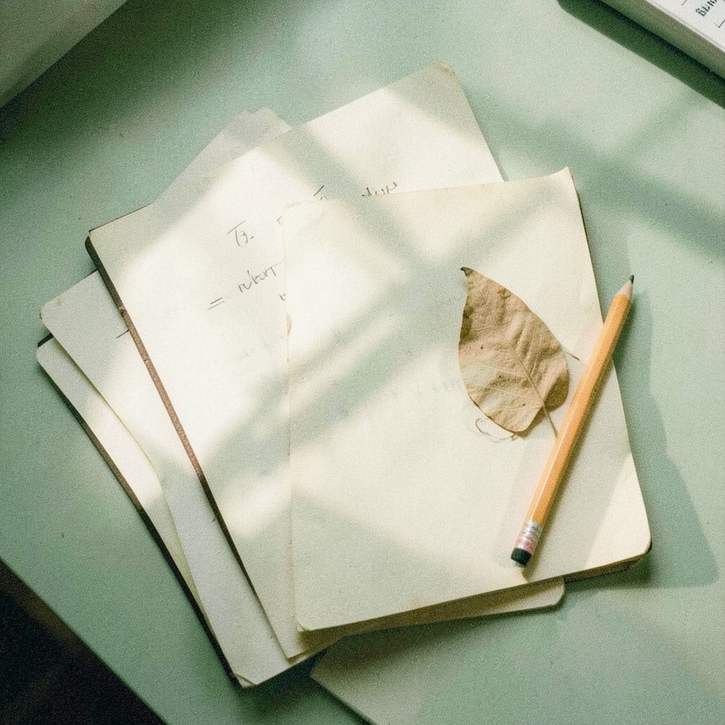A small annotated note pinned beside a bound volume on a desk